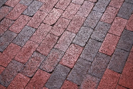 The pattern of a old pink concrete outdoor walkway under a bright sun
