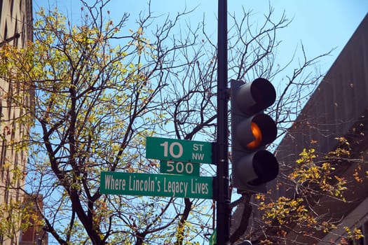Green 10 Street North West historic sign in downtown Washington D.C. with yellow traffic light, Where Lincoln's Legacy Lives