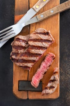 Grilled beef fillet steaks on dark table close up top view. Cooked Portioned filet mignon. Concept of summer food, meat eaters.
