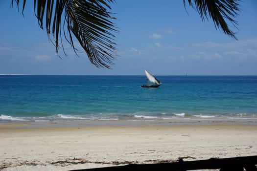 View onto the beach and a Dhow in the water from a cafe in Stone Town, Zanzibar, Tanzania 2021