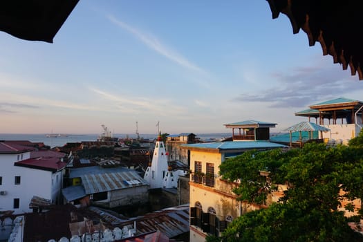 View onto the old town of Stone Town, Zanzibar at sunset, Tanzania 2021, with the princess salme museum at the right and the Shiv Shakti Temple in the middle
