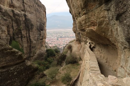Glimpse of Kalambaka between the rocks on the way to the Monastery of the Holy Trinity, Meteora, Greece