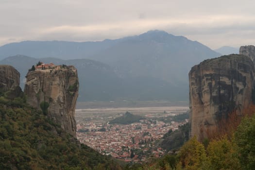 Impressive view between the rocks onto Kalambaka, the Monastery of the Holy Trinity in the front, Meteora, Greece 2021