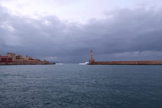Chania's seafront onto the water and it's lighthouse at a cloudy day in fall, Crete, Greece 2021