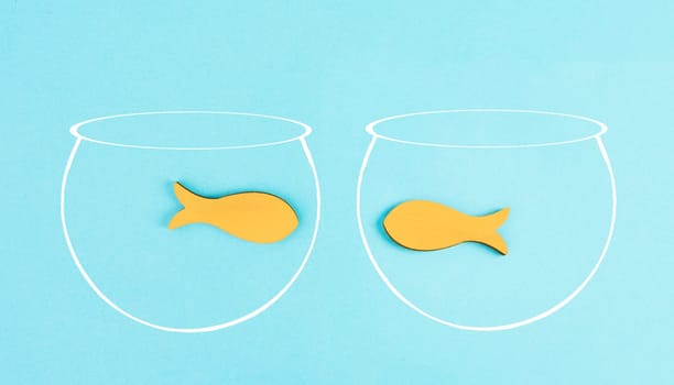 Two little fish in separated aquariums looking at each other, freedom and friendship concept, having a meeting and conversation, problem solving, helping