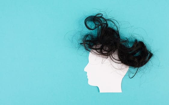 Silhouette of a face with a hairstyle, woman, man, transgender, copy space for text, portrait with dark hair, paper cut out
