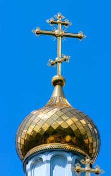 Golden cross on blue sky.