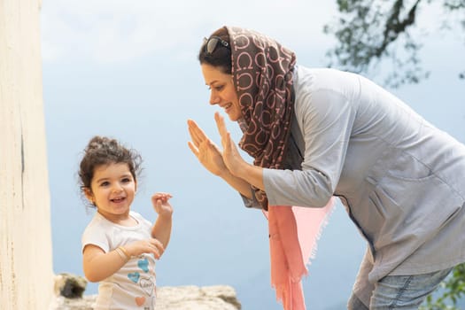 Young Muslim woman playing with her girl enjoying in the misty -fogy weather