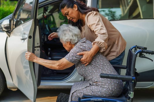 Caregiver help Asian elderly woman disability patient get in her car, medical concept.