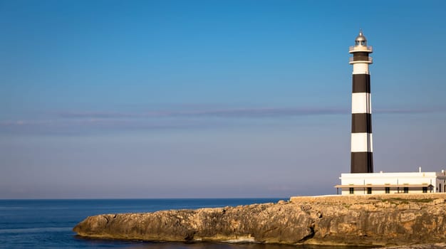 MINORCA ISLE - SPAIN - CIRCA AUGUST 2020: scenic Artrutx Lighthouse at sunset, famous landmark of the Isle