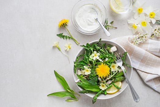 Spring salad with dandelion, asparagus, flowers, nettle and cream cheese. Healthy spring detox food ingredients.