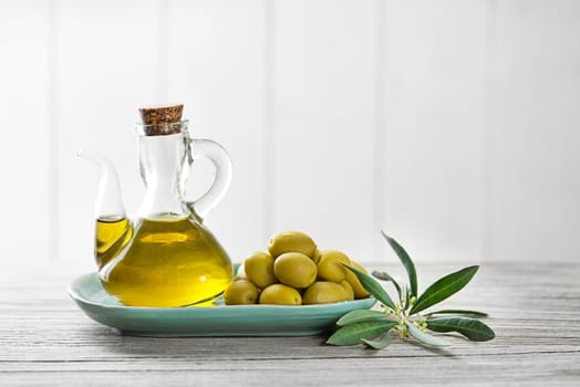 Organic olive oil. Bottle of Extra virgin oil with olives and branch leaves