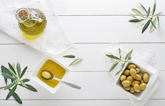 Olive oil bottle with olives and olive branch on the wooden table