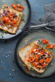 Breakfast served with toast sandwiches with tomato, onion and herbs. Bruschetta with roasted tomatoes. Continental delicious healthy breakfast table