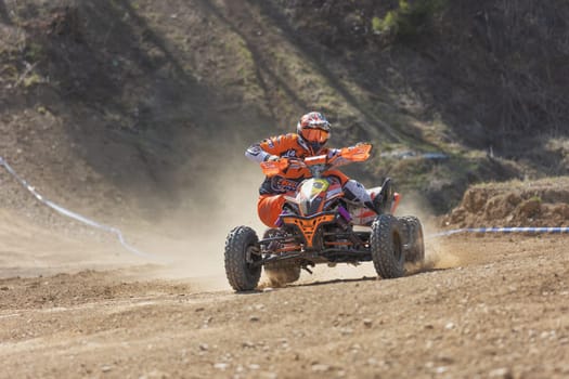 MOHELNICE,  CZECH REPUBLIC - APRIL 16, 2022: Young rider on a orange quad bike in turn in International Championship of Czech Republic in Sidecarcross, category Quad on April 16, 2022 in Mohelnice.