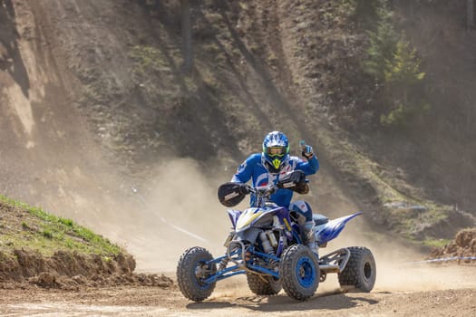 MOHELNICE,  CZECH REPUBLIC - APRIL 16, 2022: Rider on a quad bike is posing while driving in International Championship of Czech Republic in Sidecarcross, category Quad on April 16, 2022 in Mohelnice.
