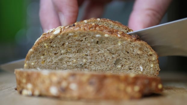 Slicing Whole Grain Bread On Wooden Table.