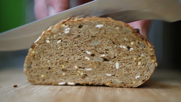 Slicing Whole Grain Bread On Wooden Table.