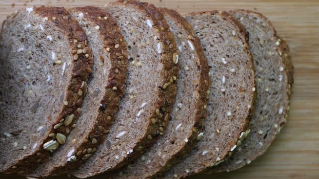 Slicing Whole Grain Bread On Wooden Table.