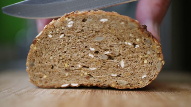 Slicing Whole Grain Bread On Wooden Table.