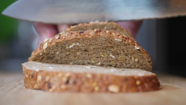 Slicing Whole Grain Bread On Wooden Table.