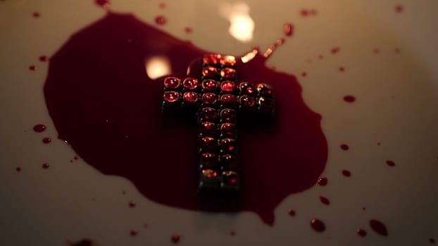 Close up of cross of jesus with blood lit by candle