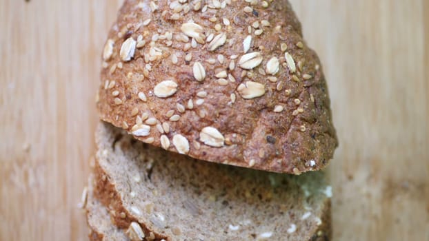 Slicing Whole Grain Bread On Wooden Table.