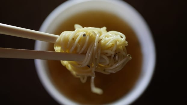 Close up of instant noodles yellow ramen and  Chinese chopsticks