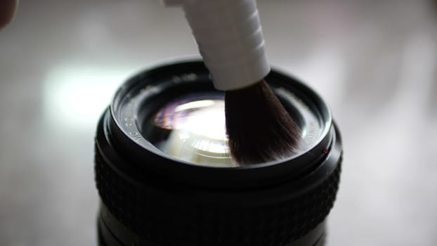 Cleaning camera lens with lens pen brush