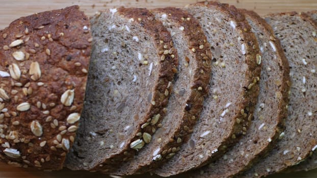 Slicing Whole Grain Bread On Wooden Table.