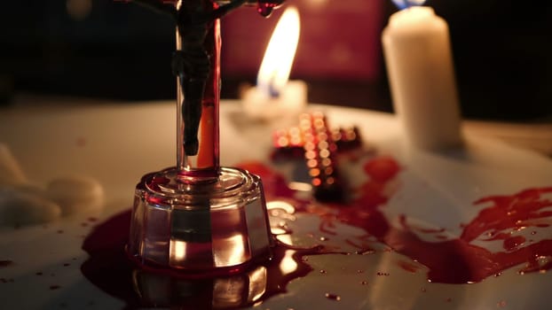 Close up of cross of jesus with blood lit by candle