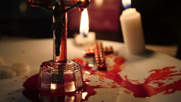 Close up of cross of jesus with blood lit by candle