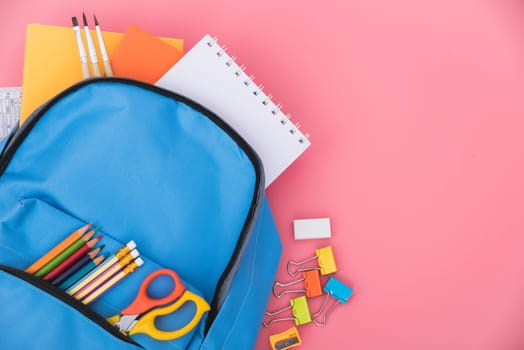 Top view flat lay of blue school bag backpack and accessories tools for children education on pink background, Back to school concept and have copy space for use