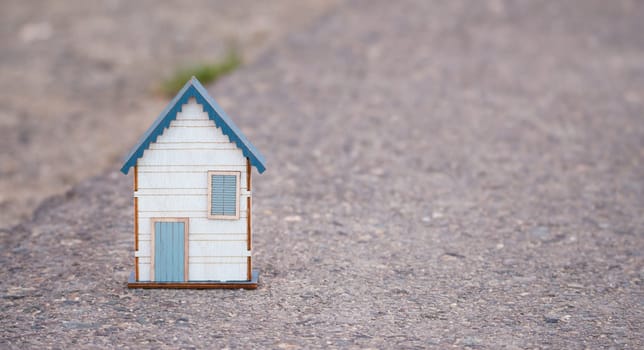 Small house standing on a road, real estate concept, renting or buying a home, travel and vacation symbol