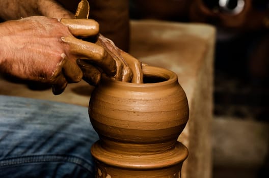 Potter shaping clay on the pottery wheel