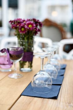 Restaurant interior details. Wineglasses and flower decoration.
