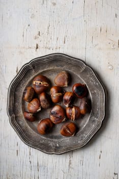 Roasted chestnuts in rustic silver plate