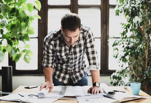 Young man working on architectural project. Modern office concept