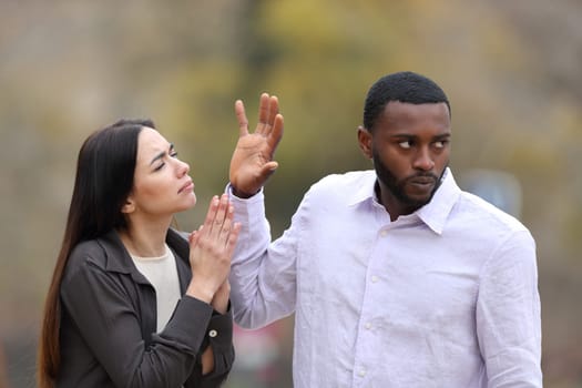 Man rejecting a woman who is begging