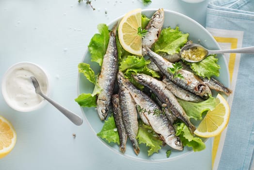 Grilled sardines with lemon and herbs close up. Healthy vegetarian fish meal