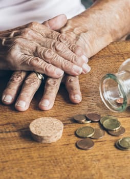 Elderly retired woman and her savings in a jar