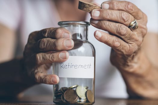 Elderly retired woman and her savings in a jar