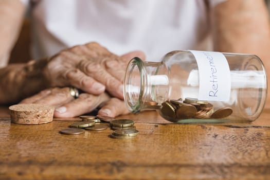 Elderly retired woman and her savings in a jar