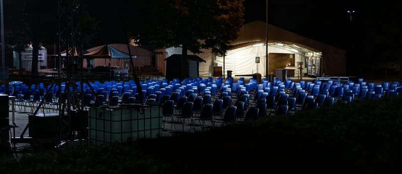 desolating rows of empty seats, in a place commonly used for outdoor performances now abandoned and waiting for the end of the pandemic, with the risk of business failure, night scene