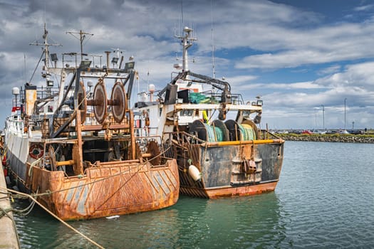 Two old and rusty fishing boats moored in Howth harbour. Phishing and shellfish fishing equipment on fishing boats, Dublin, Ireland