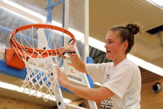Snap,Luisa Nufer (USC Eisvögel Freiburg) uses scissors to separate a piece of net from the basketball hoop secured as a souvenir for the German Championship after the game of the 1.BBL Women 2021/2022 - Eisvoegel USC Freiburg - Rheinland Lions. .. Photo: Joachim Hahne/johapress