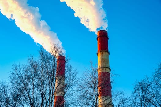 white smoke is coming out of the pipes in the blue sky. High quality photo