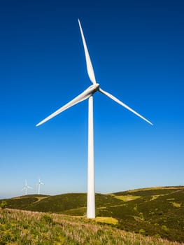 Wind turbines on a beautiful blue sky in a mountain wind farm in Sardinia. Renewable energy concept, green energy generation. Energy industry.
