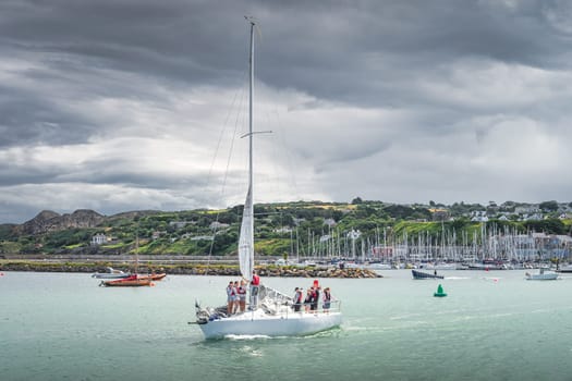 Dublin, Ireland, Aug 2019 Tanagers learning how to sail. Group of people on a sailboat in Howth marina