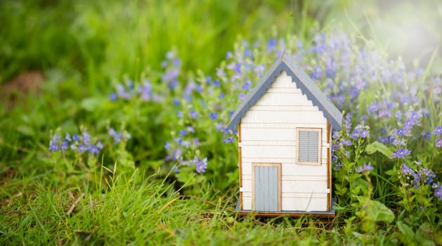 Wooden house in a meadow, buying or renting a house in nature, real estate concept, booking home for vacation, copy space for text
